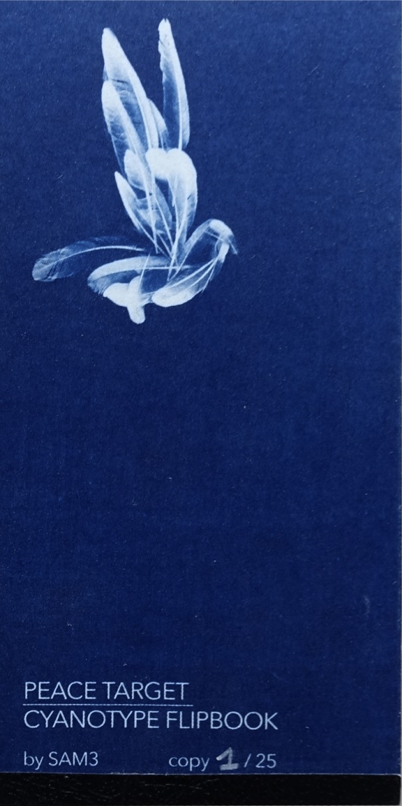Front cover of a small cyanotype flipbook in deep blue, showing a white bird formed by overlapping feather silhouettes in the upper half and white printed text at the bottom with the title, the author's name and the copy number 1/25 handwritten.