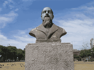 Animated documentation view of the bronze bust monument on its stone pedestal in the park.